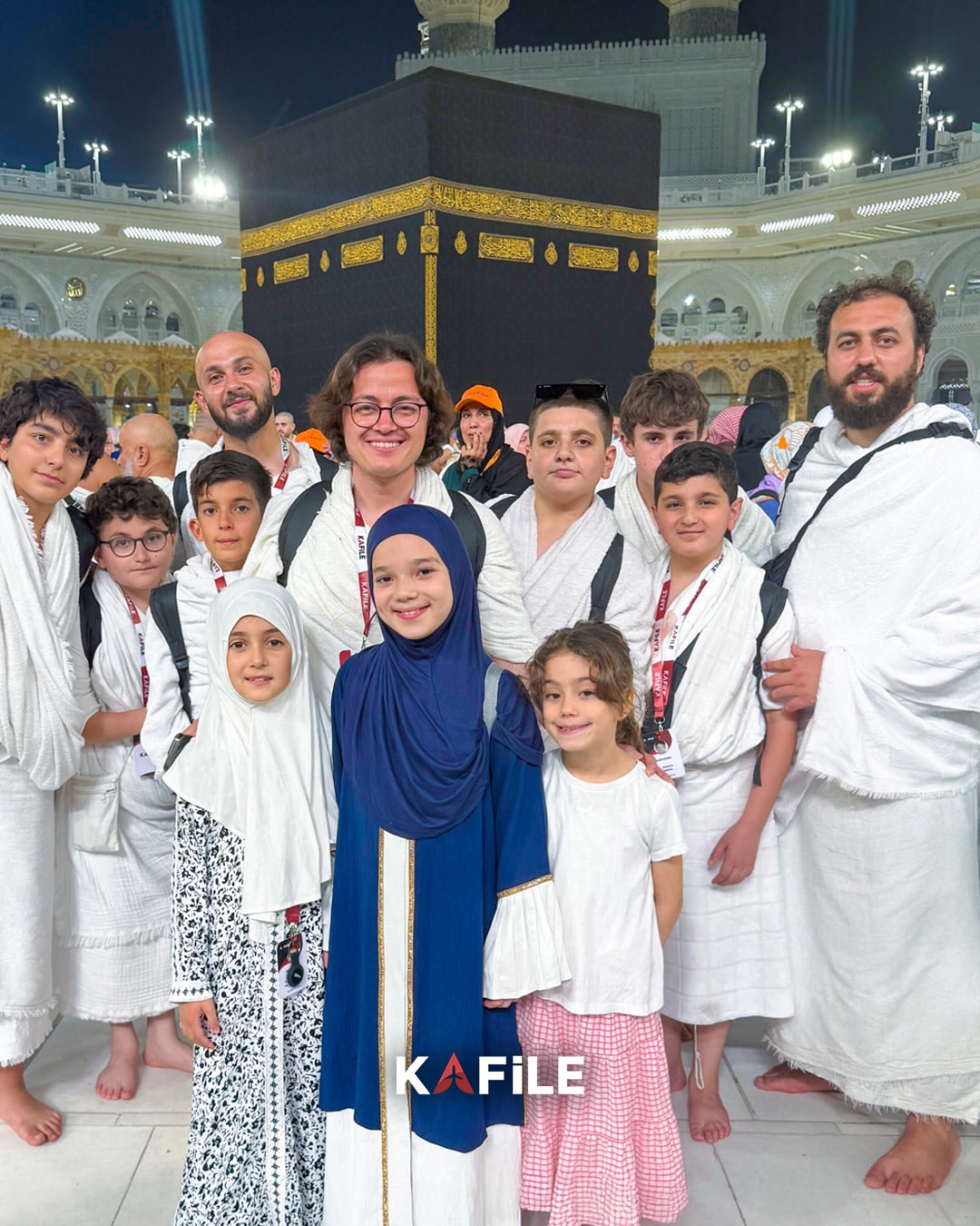 Kâbe önünde çocuklarıyla birlikte hatıra fotoğrafı çeken Kafile Turizm umre grubu